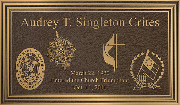 religious bronze plaque with bronze cross and logos